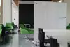 an empty room of green and black chairs, tables, and whiteboards